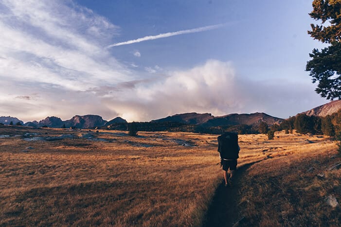 Man Backpacking Through Mountains