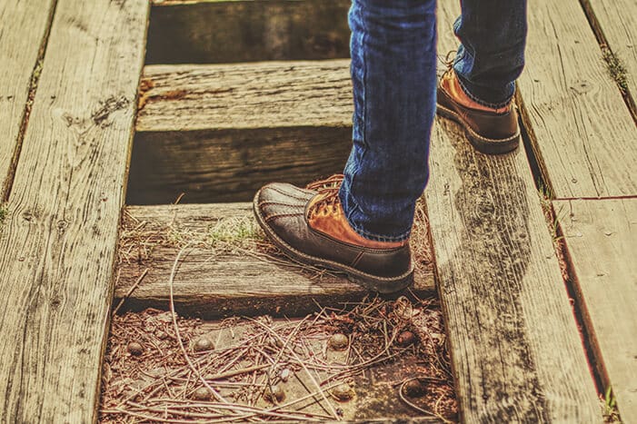 Man in Boots and Jeans Standing on a Bridge